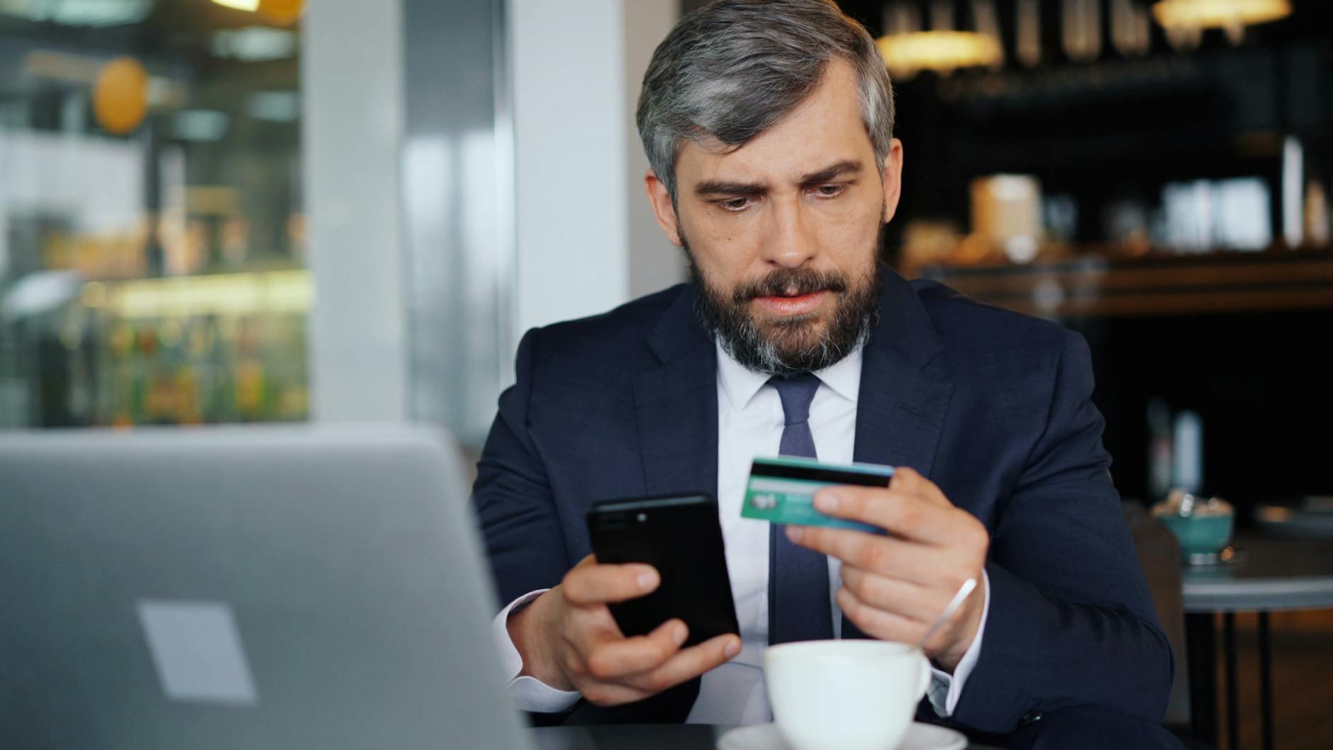 Dirigeant de TPE comparant une néobanque et une banque pro sur smartphone