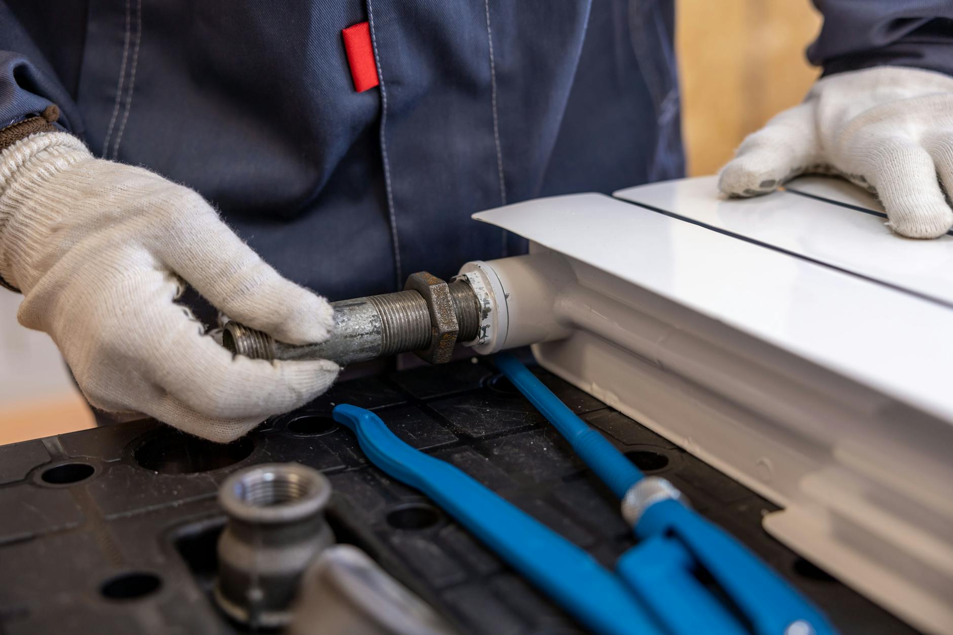 Artisan plombier intervenant sur une installation de chauffage chez un client