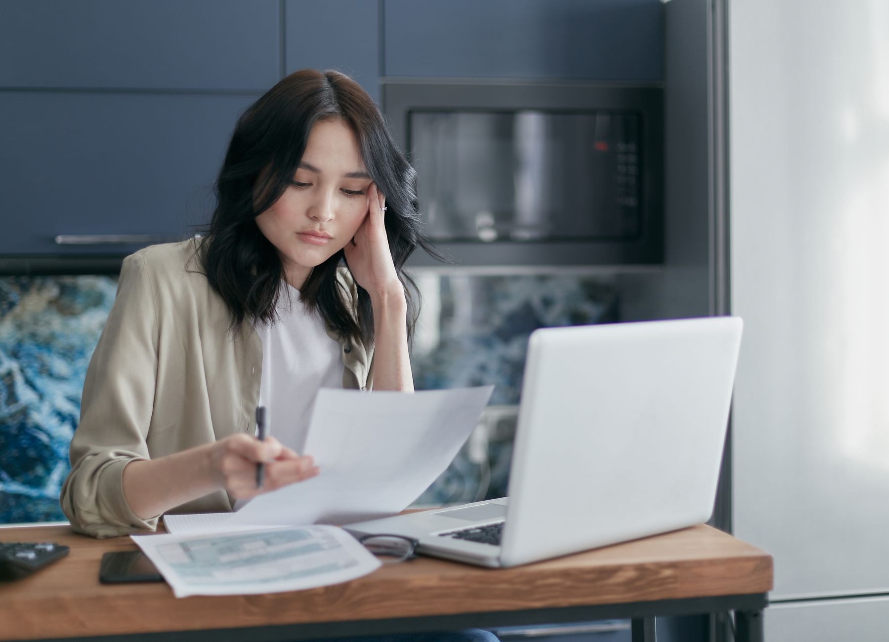 Auto-entrepreneur consultant ses factures électroniques sur ordinateur portable dans son bureau à domicile