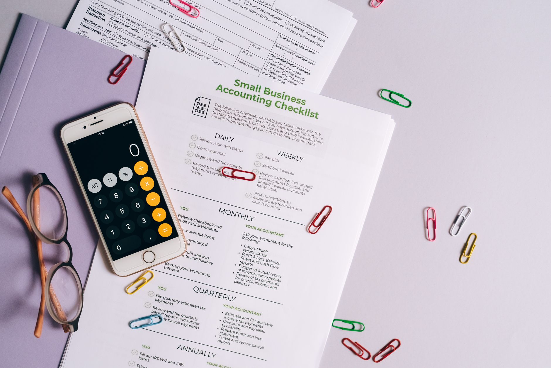 Documents de facturation et calculatrice d'un micro-entrepreneur se préparant à la réforme 2026
