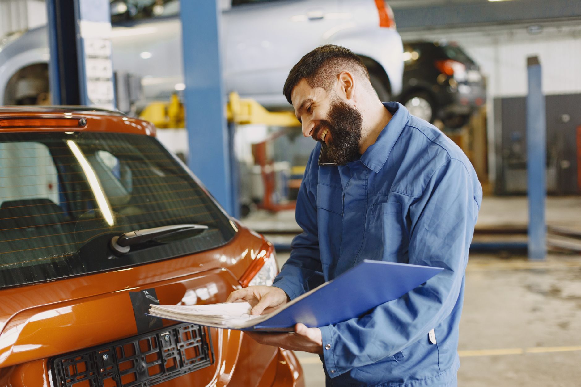 Mécanicien dans un garage automobile consultant une facture électronique sur tablette